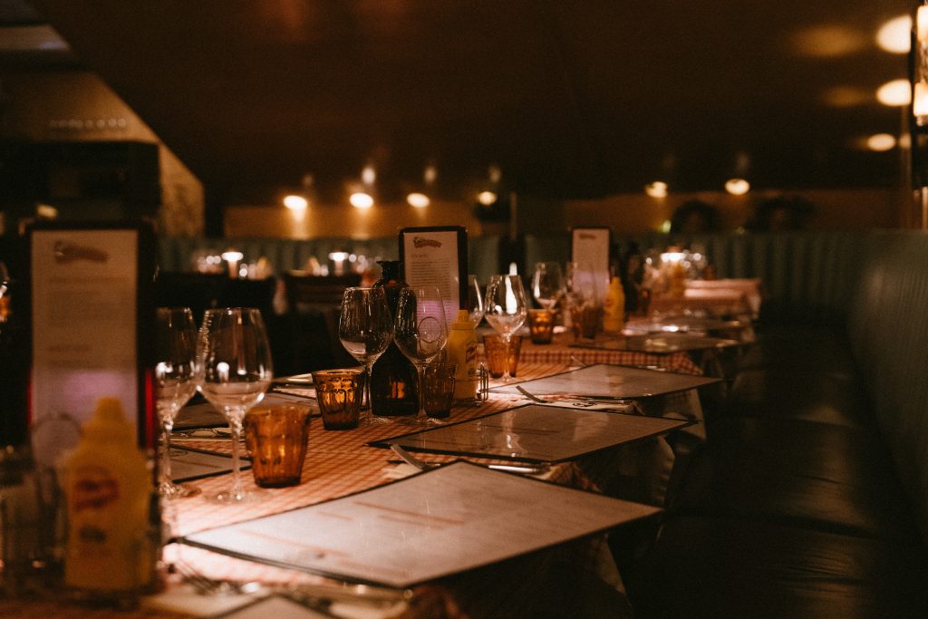 Dukat bord med vinglas och menyhållare i den mörka, stämningsfulla matsalen på Joe Farelli's
